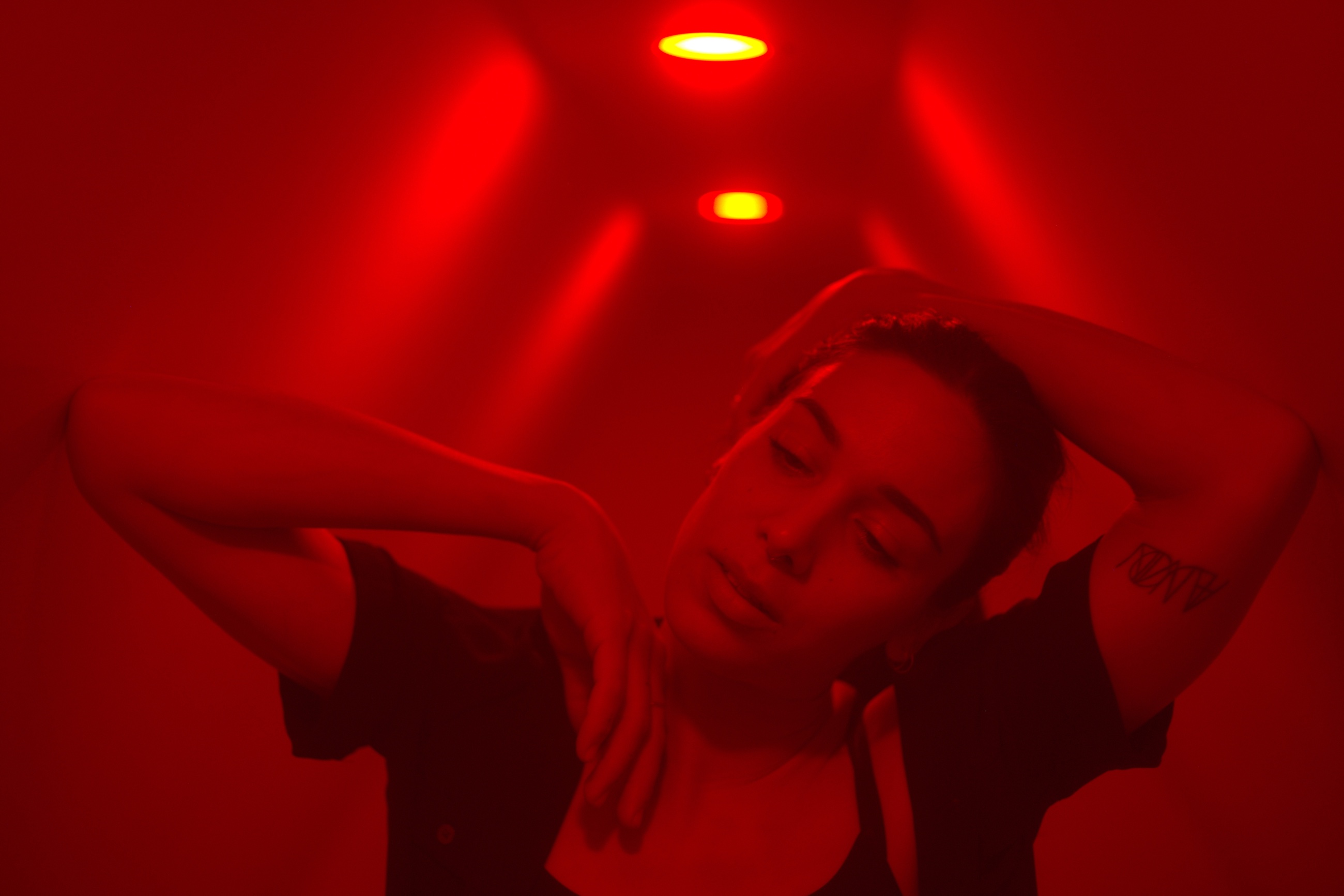 Olivia Bortolazzo as Stella performing beneath vivid red light in Starry Eyed